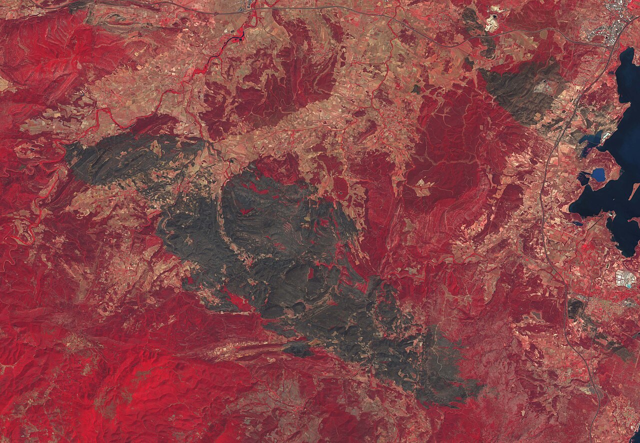 资料中的Copernicus Sentinel-2伪彩色地球观测图,可见红色地表和植被、较暗区域、道路以及水域。