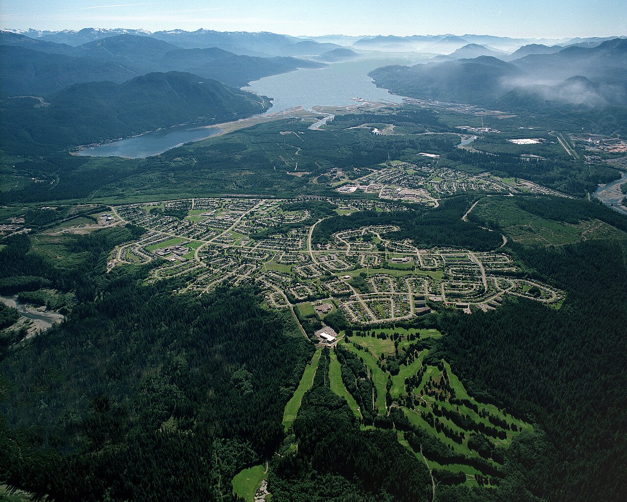 Kitimat 的资料航拍图，可见城镇、森林覆盖的山谷、Douglas Channel 以及远处山脉。