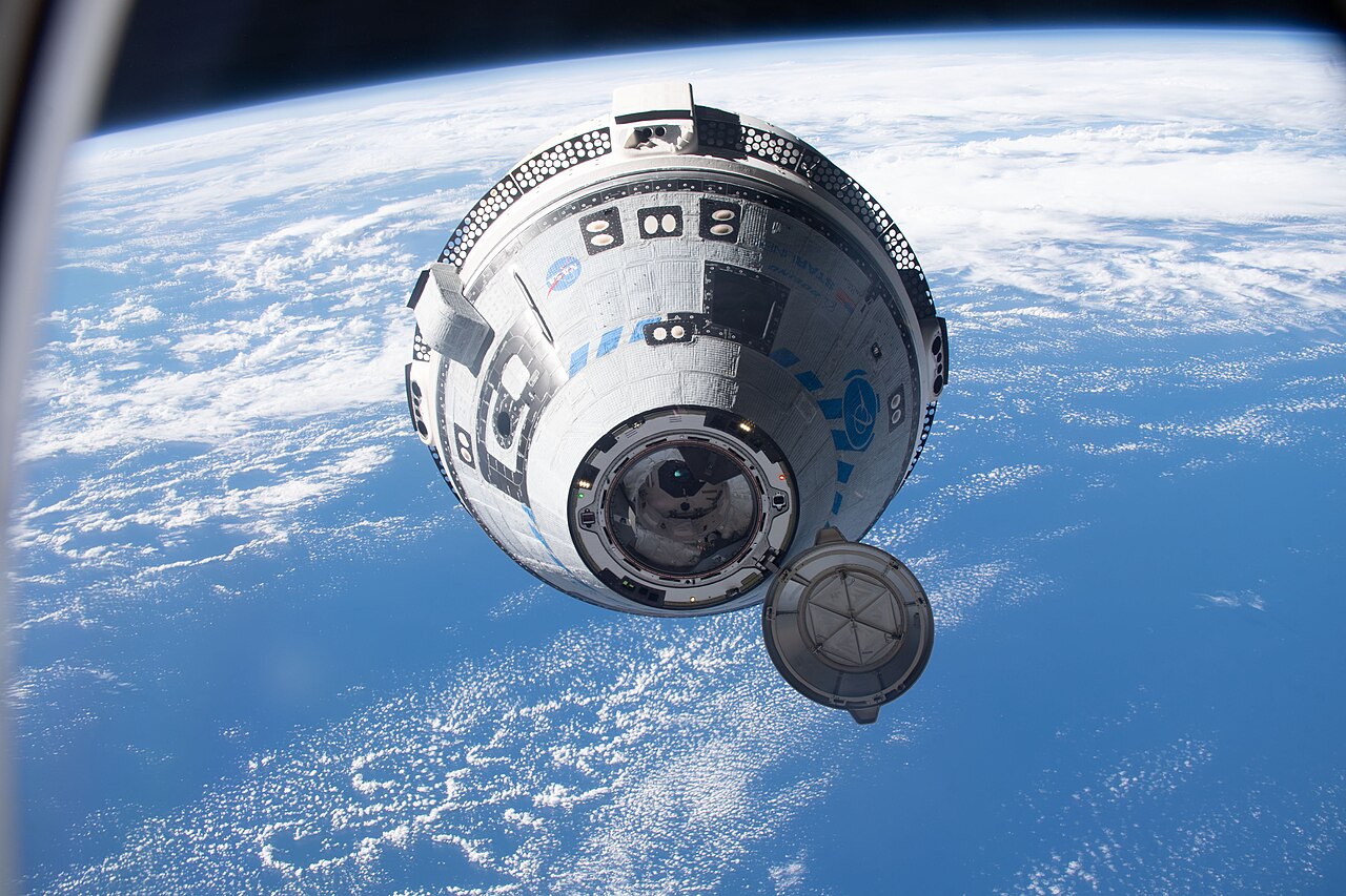 NASA资料照片：波音Starliner接近国际空间站，背景可见地球。